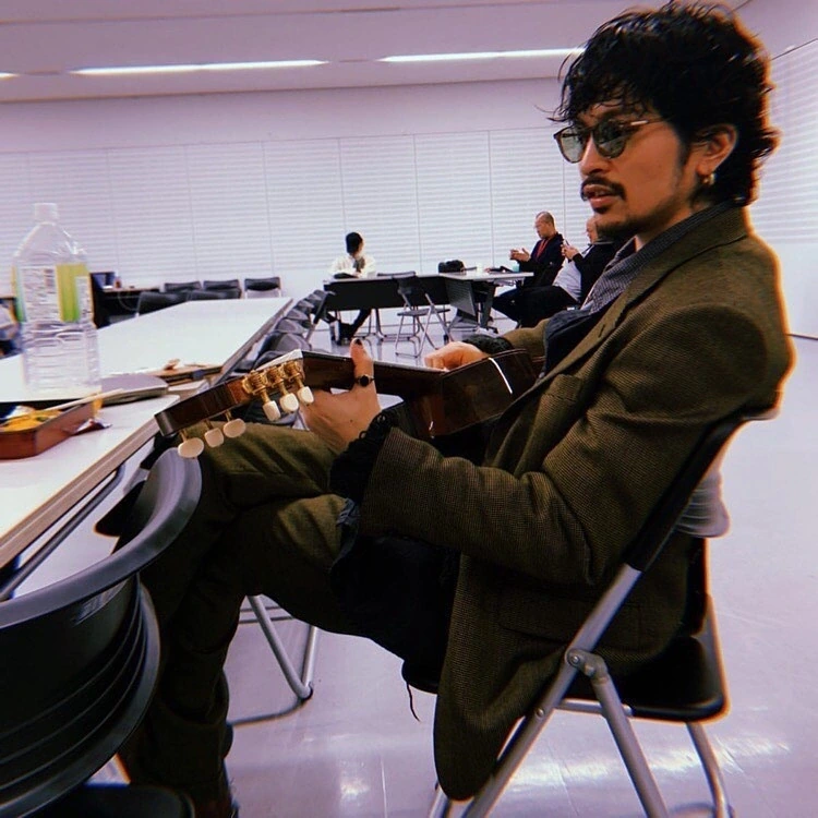 常田大希さんがMステ「どろん」披露時の楽屋でギターを手にBOSTON CLUBのHUDSONを着用した横顔ショット