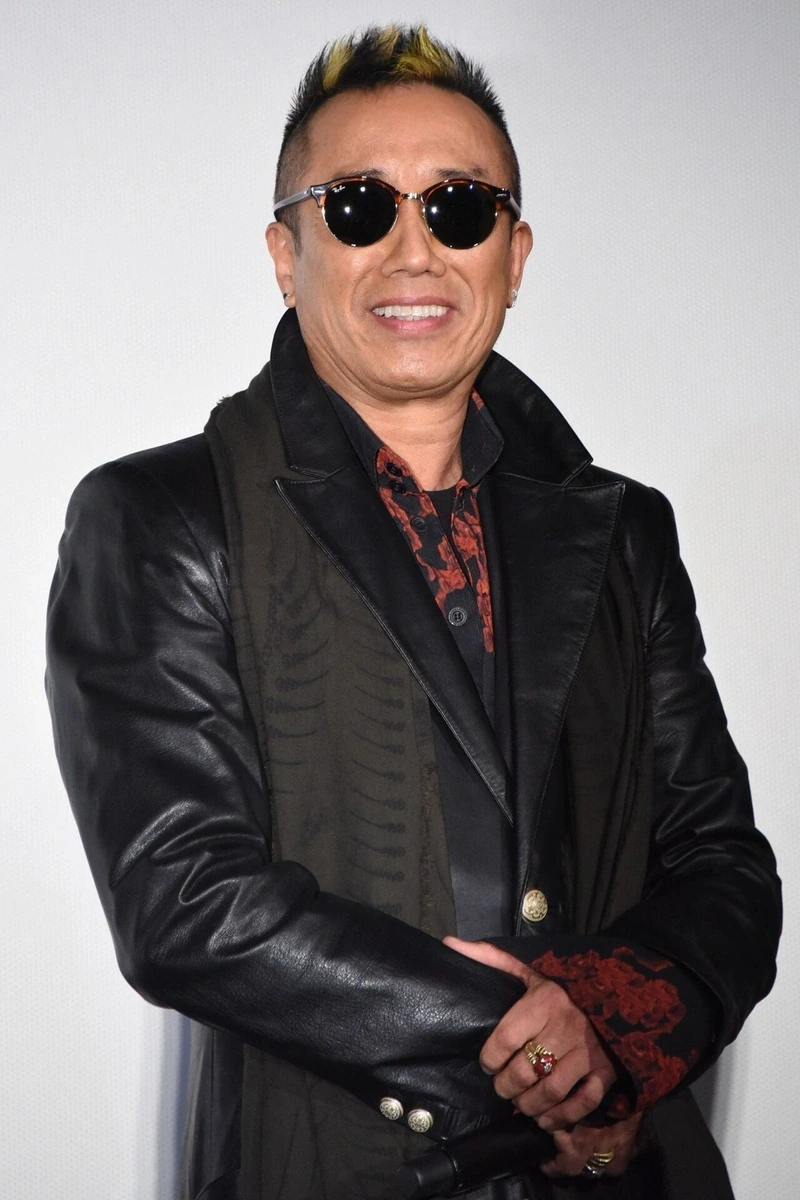 長渕剛さんが映画『太陽の家』の舞台挨拶でレザーコートにRay-BanのCLUBROUNDを着用し笑顔を見せるショット
